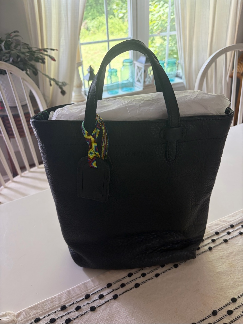 Consuela Evie Black Leather Tote with Multicolor Charm and Crossbody Strap.